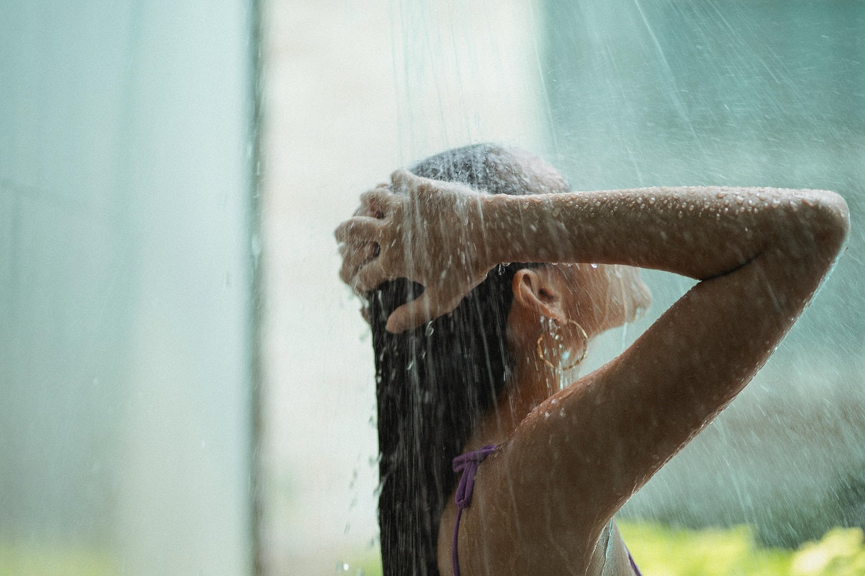 A woman washing her hair in a refreshing shower.