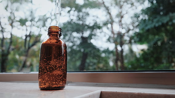 An amber glass bottle with a glass dropper.