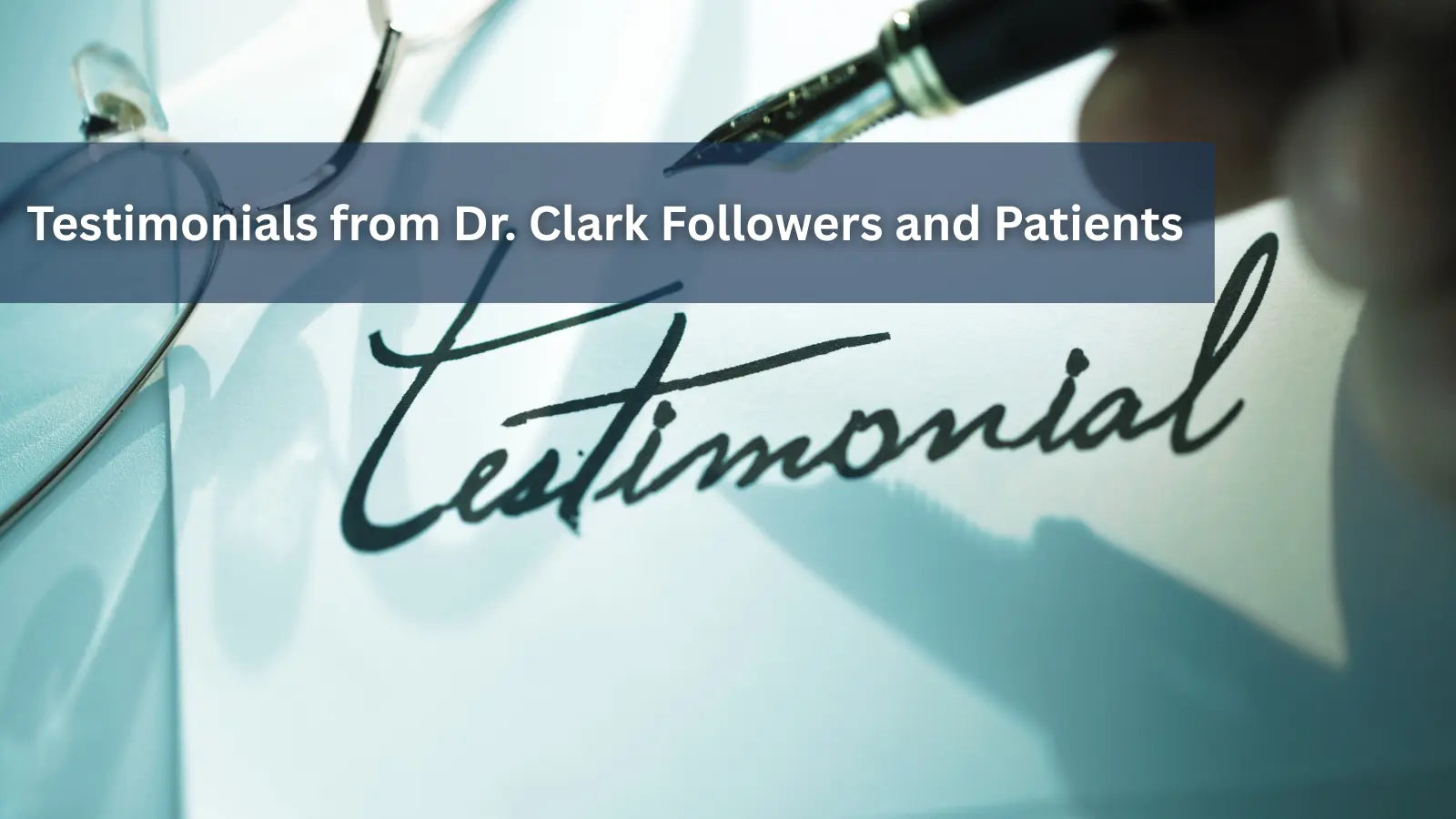 A close-up of a fountain pen writing the word "Testimonial" in cursive on a piece of paper next to a pair of glasses.